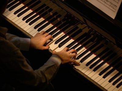 Close up shot taken from above a student who is playing the piano